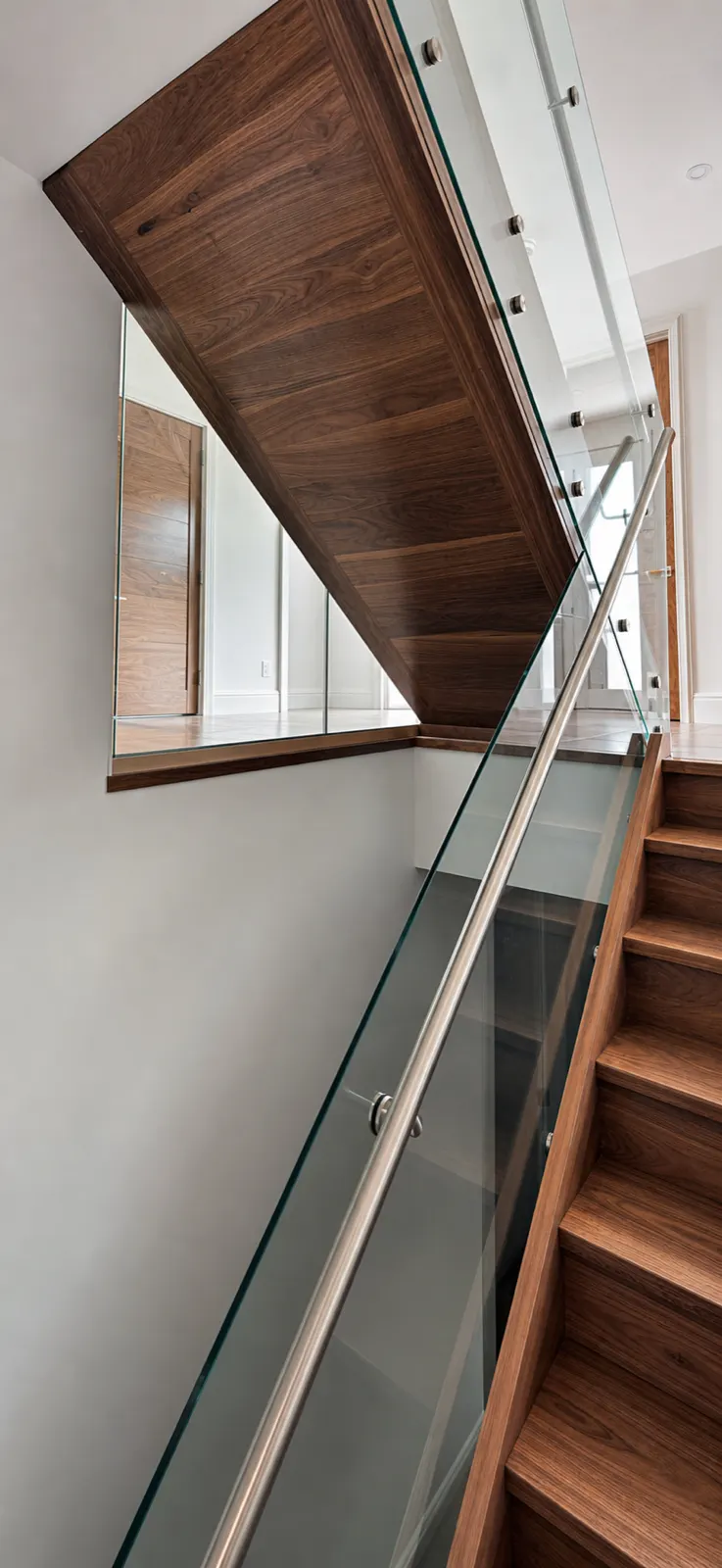 Custom walnut staircase with glass railing by JP